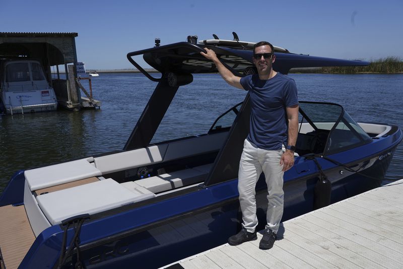 Mitch Lee, co-founder and CEO of Arc Boats, stands in front of an Arc Sport, an electric boat made by his California company, in Bethel Island, Calif. on Wednesday, July 31, 2024. (AP Photo/Terry Chea)