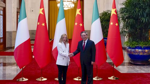 Italy's Prime Minister Giorgia Meloni shakes hands with Chinese Premier Li Qiang in Beijing, Sunday, July 28, 2024, ahead of a forum with Italian and Chinese business leaders. Meloni is on an official visit to China this week to try to reset relations at a time of both fears of a trade war with the European Union and continued interest in attracting Chinese investment in auto manufacturing and other sectors. (Filippo Attili/Italian Premier Press Office Via AP)