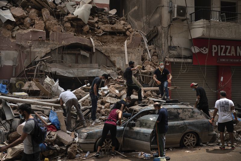 FILE - People remove debris from a house damaged by a massive explosion in the seaport of Beirut, on Aug. 7, 2020. (AP Photo/Felipe Dana, File)