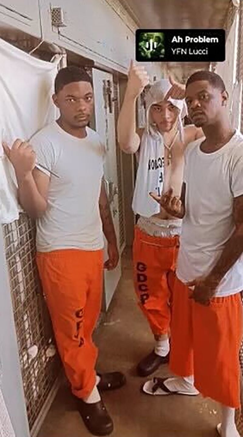 In this image captured from a social media post, Shane Tassi, center, displays a homemade shank and is making a gesture suggesting his gang affiliation. (Ocmulgee Judicial Circuit District Attorney's Office)