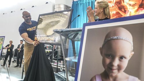 September 20, 2019  Hartsfield-Jackson International Airport: Dr. Kofi Smith, President & CEO, Atlanta Airlines Terminal Company (left) unveils a picture of the gold canopy as Dean Crowe, Founder & CEO, Rally Foundation for Childhood Cancer Research (right)  applauds. JOHN SPINK/JSPINK@AJC.COM