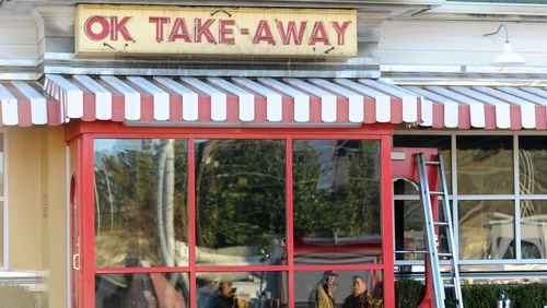 Fire fighters are reflected int he takeout window as they investigate a blaze at the OK Cafe restaurant during the morning breakfast rush on Sunday, Dec. 7, 2014, in Atlanta. (AJC Special/David Tulis)