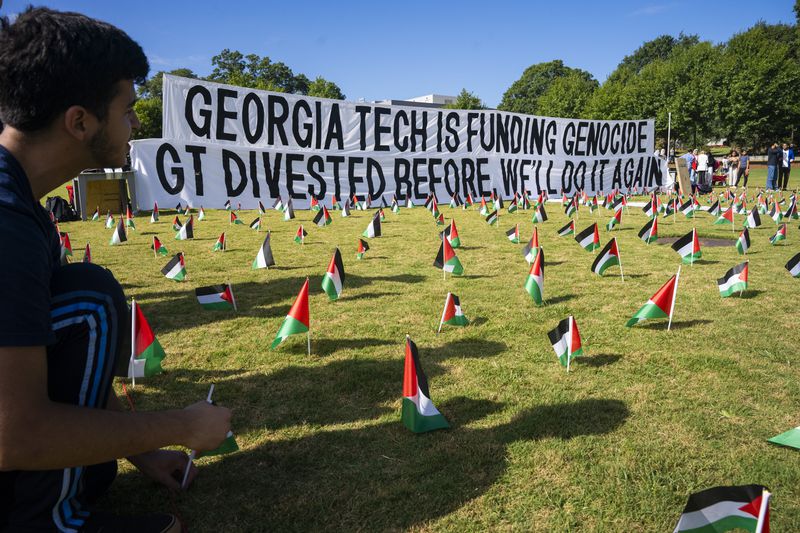 A first-year student places flags around a memorial on the Georgia Tech campus green in honor of the Palestinian victims who have lost their lives in the Israel-Hamas war. Olivia Bowdoin for the Atlanta Journal-Constitution