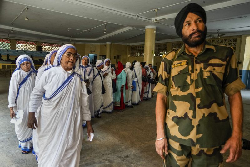 An Indian para-military force soldier stands guard as nuns of the Missionaries of Charity, the order founded by Saint Teresa, stand in queue to cast their votes during the last round of a six-week-long national election, in Kolkata, India, Saturday, June 1, 2024. Indians began voting Saturday in the last round of a six-week-long national election that is a referendum on Hindu nationalist Prime Minister Narendra Modi’s decade in power. (AP Photo/Bikas Das)
