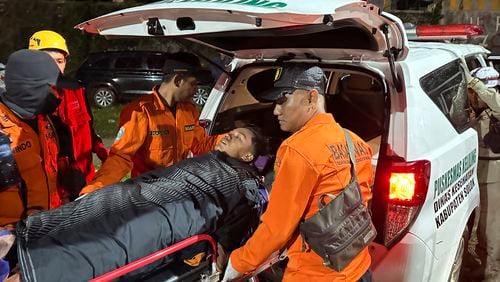 Rescuers transfer a survivor into an ambulance after a landslide set off by torrential rains smashed down into an unauthorized gold mining operation, killing several people, in Solok, West Sumatra, Indonesia, Saturday, Sept. 28, 2024. (AP Photo/John Nedy)