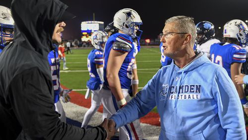 Walton Raider head coach Daniel Brunner (right) greets Camden County head coach Jeff Herron at the conclusion of their GHSA semifinal game Friday, December 1, 2023. Walton beat Camden County 41-25. (Daniel Varnado/For the AJC)