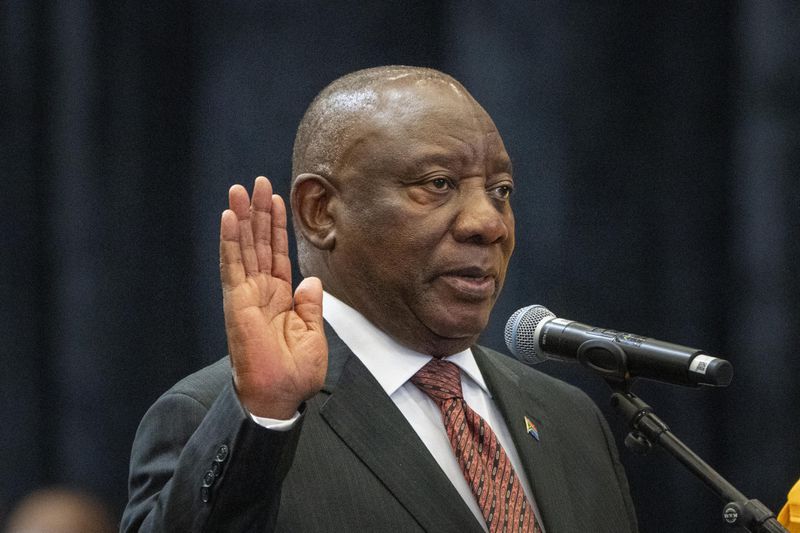 South African President Cyril Ramaphosa raises his hand as he is sworn is as a member of Parliament ahead of an expected vote by lawmakers to decide if he is reelected as leader of the country in Cape Town, South Africa, Friday, June 14, 2024. (AP Photo/Jerome Delay)
