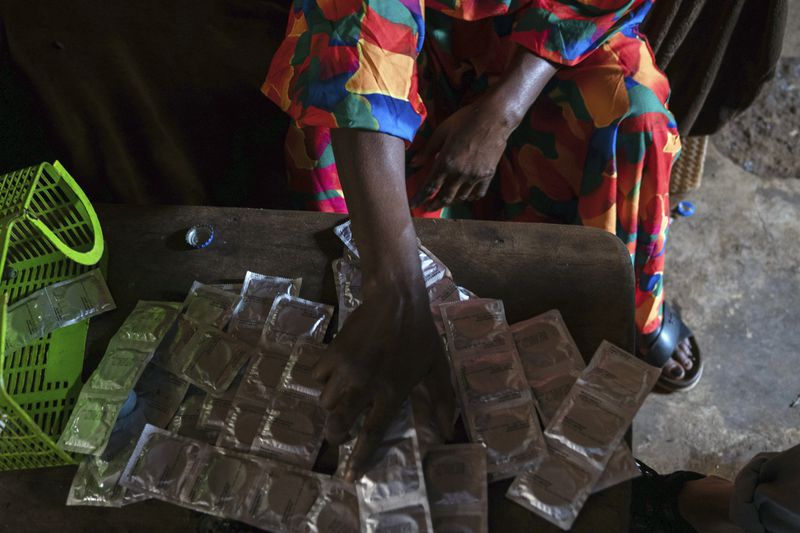 Sifa Kunguja, a 40-year-old sex worker, sorts through condoms at home after recovering from mpox Wednesday, Sept. 4, 2024 in Kamituga, eastern Congo. (AP Photo/Moses Sawasawa)