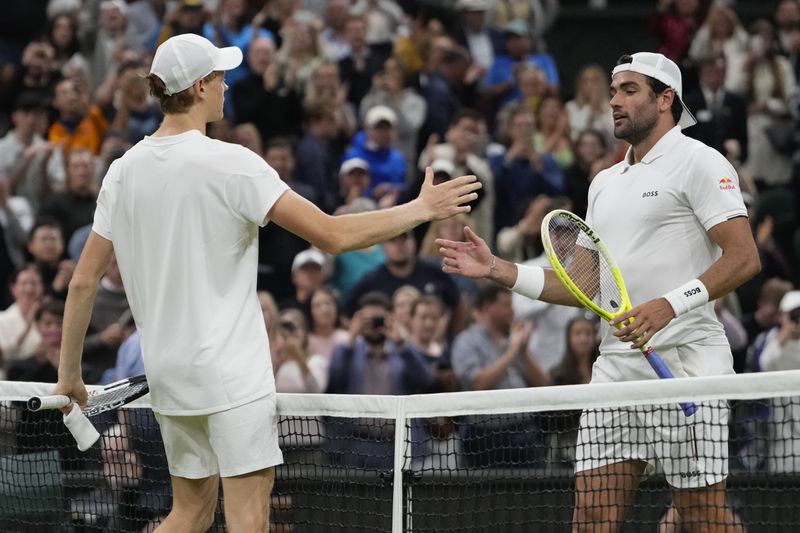 Jannik Sinner, left, of Italy is congratulated by compatriot Matteo Berrettini following their second round match at the Wimbledon tennis championships in London, Wednesday, July 3, 2024. (AP Photo/Alberto Pezzali)
