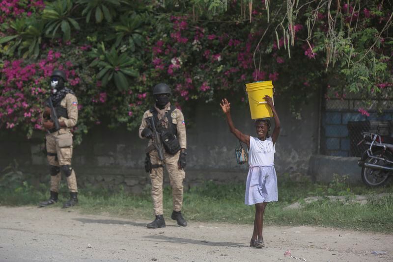 A street vendor walks past police officers ahead of the arrival of U.S. Secretary of State Antony Blinken in Port-au-Prince, Haiti, Thursday, Sept. 5, 2024. (AP Photo/Odelyn Joseph)