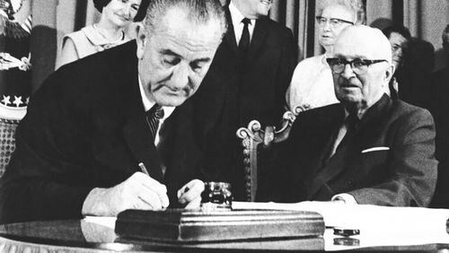 FILE - President Lyndon B. Johnson signs the Medicare bill in Independence, Mo., July 30, 1965. At right is former President Harry Truman. The Supreme Court's pending Idaho abortion ruling may hinge on how federal spending power might protect doctors against a state's criminal code. For guidance, the justices can look to the very beginning of Medicare in the 1960s, when the promise of federal funding finally persuaded hospitals in the Jim Crow South to desegregate. (AP Photo, File)