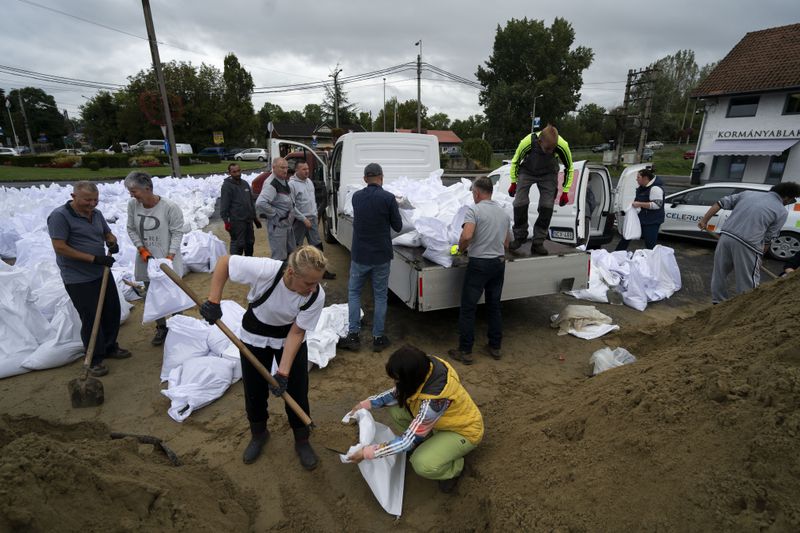 People fill sandbags to reinforce the dam due to the flooding of the Danube river at Tahitotfalu, Hungary, on Monday, Sept. 16, 2024. (AP Photo/Denes Erdos)