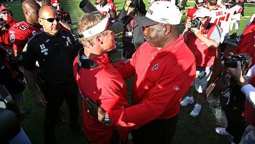 Falcons interim coach Emmitt Thomas and Buccaneers coach Jon Gruden meet on the field after the Bucs defeated the Falcons 37-3.