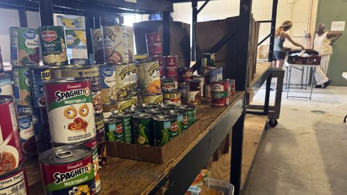 Stacks of donated goods line the shelves at the Good News Outreach food bank, Wednesday, July 31, 2024, in Tallahassee, Fla. Florida is one of 13 states that is not participating in a federal hunger relief program this summer that helps families in need buy groceries. (AP Photo/Kate Payne)