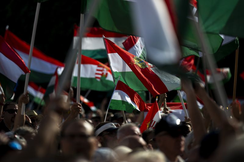 People wave the Hungarian national flag during Péter Magyar's speech at a campaign rally in the rural city of Debrecen, Hungary, on May 5, 2024. Magyar, 43, seized on growing disenchantment with the populist Prime Minister Viktor Orbán, building a political movement that in only a matter of weeks looks poised to become Hungary's largest opposition force. (AP Photo/Denes Erdos)