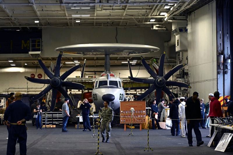 Crew members walk by aircraft in the hanger of the Theodore Roosevelt (CVN 71), a nuclear-powered aircraft carrier, anchored in Busan Naval Base in Busan, South Korea Saturday, June 22, 2024. (Song Kyung-Seok/Pool Photo via AP)
