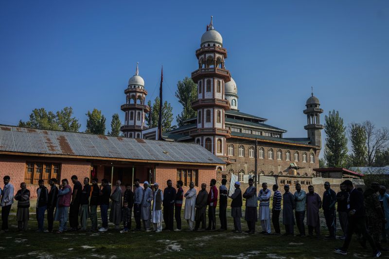 Kashmiris queue up at a polling booth to cast their vote during the final phase of an election to choose a local government in Indian-controlled Kashmir, north of Srinagar, Tuesday, Oct.1, 2024. (AP Photo/Mukhtar Khan)