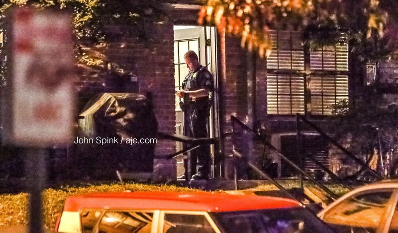 Officers check with neighbors at the Roswell Court Condominiums after a woman was fatally shot Wednesday morning.