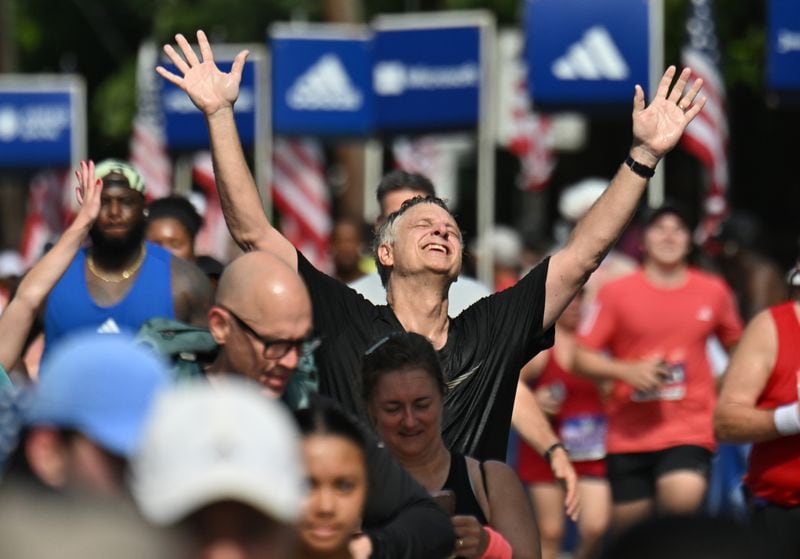 Runners celebrate at the finish of the 55th running of the Atlanta Journal-Constitution Peachtree Road,Thursday, July 4, 2024, in Atlanta. (Hyosub Shin / AJC)