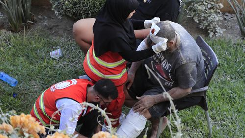 FILE - Paramedics treat a man who was injured after an Israeli airstrike hit two adjacent buildings east of the southern port city of Sidon, Lebanon, Sunday, Sept. 29, 2024. (AP Photo/Mohammed Zaatari, File)