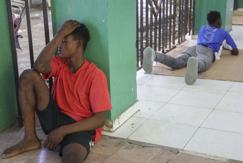 Relatives of people injured during armed gang attacks wait around at Saint Nicolas hospital in Saint-Marc, Haiti, Sunday, Oct. 6, 2024. (AP Photo/Odelyn Joseph)