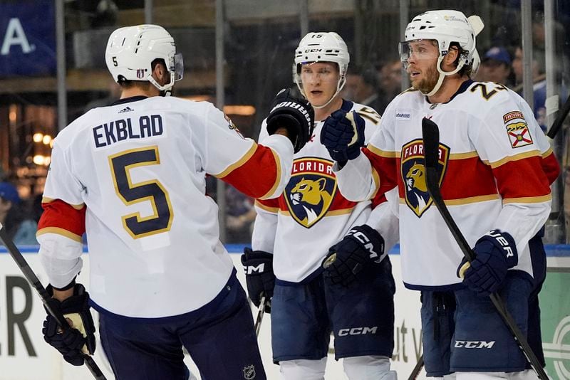Florida Panthers defenseman Aaron Ekblad (5), center Carter Verhaeghe (23) and center Anton Lundell (15) celebrate a goal by Florida Panthers left wing Matthew Tkachuk against the New York Rangers during the first period of Game 1 of the NHL hockey Eastern Conference Stanley Cup playoff finals, Wednesday, May 22, 2024, in New York. (AP Photo/Julia Nikhinson)