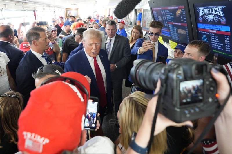 Republican presidential candidate former President Donald Trump, center, greets customers and staff at Tony and Nick's Steaks, Saturday, June 22, 2024, in Philadelphia. (AP Photo/Chris Szagola)