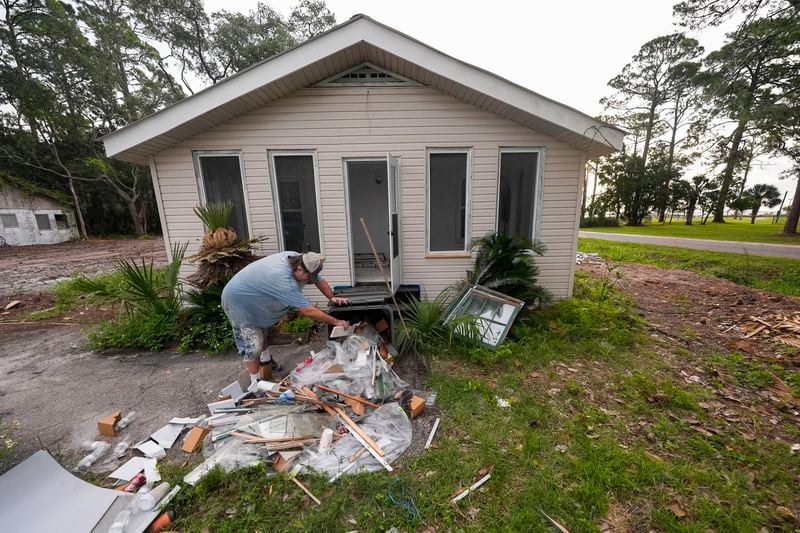 Will Marx cleans up remodeling debris in advance of Tropical Storm Helene, expected to become a hurricane before landfall, in Panacea, Fla., Wednesday, Sept. 25, 2024. (AP Photo/Gerald Herbert)