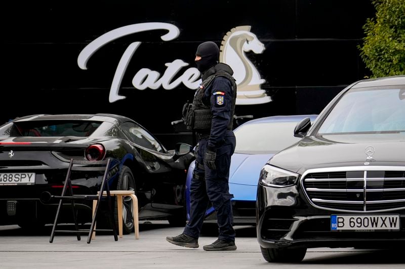 A masked gendarme patrols the courtyard of the residence of social media personality Andrew Tate during an early morning police search raid, on the outskirts of Bucharest, Romania, Wednesday, Aug. 21 2024. (AP Photo/ Vadim Ghirda)