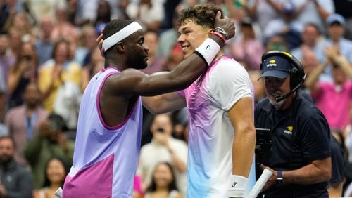 Frances Tiafoe, of the United States, left, talks with Ben Shelton, of the United States, at the net after winning their third round match of the U.S. Open tennis championships, Friday, Aug. 30, 2024, in New York. (AP Photo/Seth Wenig)