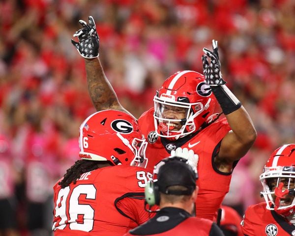 Georgia running back Kendall Milton (right) gets a hoist from Zion Loge to celebrate his touchdown run to take a 31-7 lead over Kentucky during the 2nd quarter in a NCAA college football game on Saturday, Oct. 7, 2023, in Athens.  Curtis Compton for the Atlanta Journal Constitution