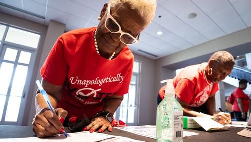 Elaine Shavers Campbell, the president of the Savannah Alumnae Chapter of Delta Sigma Theta Sorority Inc., writes down her information as a volunteer for a voter mobilization event at New Birth Missionary Baptist Church in Stonecrest, GA on Saturday, July 20, 2024. (Seeger Gray / AJC)