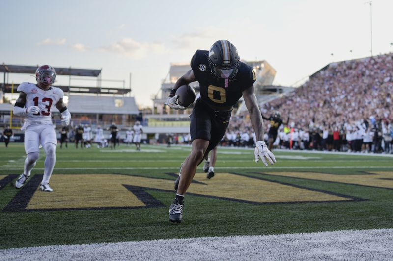 Vanderbilt wide receiver Junior Sherrill (0) makes a catch for a touchdown past Alabama defensive back Malachi Moore (13) during the second half of an NCAA college football game Saturday, Oct. 5, 2024, in Nashville, Tenn. (AP Photo/George Walker IV)