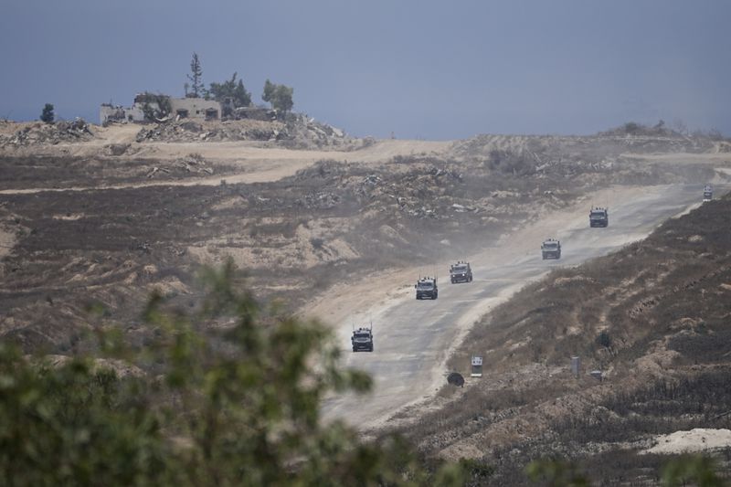 A column of Israeli military vehicles leave the Gaza Strip, as seen from southern Israel, Wednesday, June 12, 2024. (AP Photo/Tsafrir Abayov)