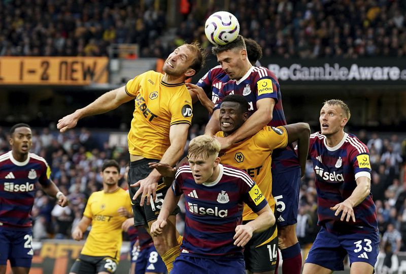 Newcastle United's Fabian Schar heads clear during the British Premier League soccer match between Wolverhampton Wanderers and Newcastle United, at Molineux Stadium, Wolverhampton, England, Sunday, Sept. 15, 2024. (David Davies/PA via AP)