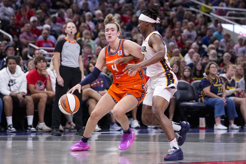 Connecticut Sun guard Marina Mabrey (4) drives on Indiana Fever guard Erica Wheeler (17) in the first half of a WNBA basketball game in Indianapolis, Wednesday, Aug. 28, 2024. (AP Photo/Michael Conroy)