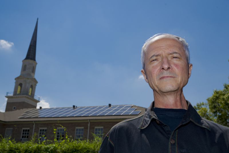 Pastor Shawn Moses Anglim poses for a photo in front of the First Grace United Methodist Church with solar panels that is part of the Community Lighthouse initiative that uses microgrids, a small-scale power system that can operate and provide electricity amid hurricanes, in New Orleans, Wednesday, Sept. 25, 2024. (AP Photo/Matthew Hinton)