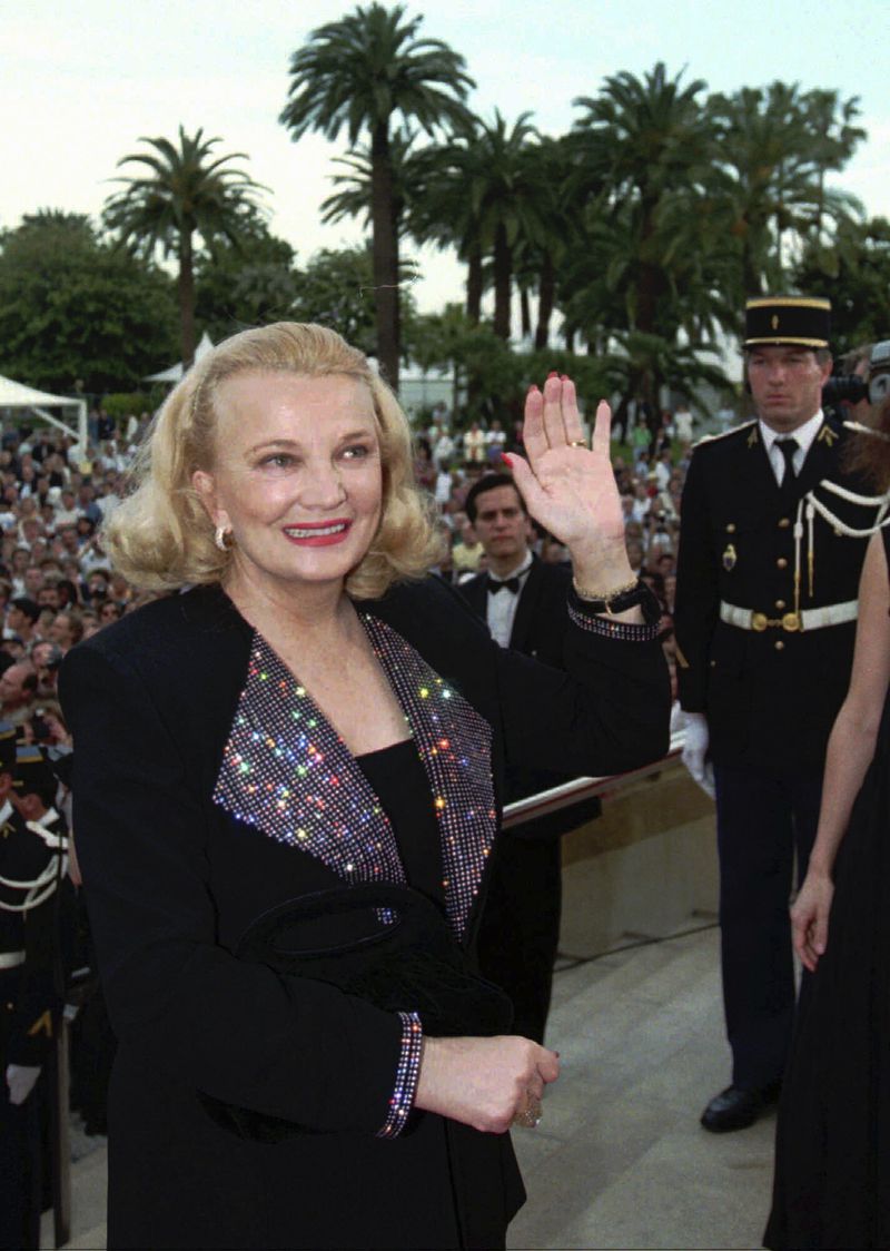 FILE - U.S. actress Gena Rowlands waves to the crowd as she arrives at the Festival Palace in Cannes Tuesday May 23, 1995, to attend the screening of Terence Davies' "The Neon Bible" for the 48th International Film Festival. Rowlands, hailed as one of the greatest actors to ever practice the craft and a guiding light in independent cinema as a star in groundbreaking movies by her director husband, John Cassavetes, and later charmed audiences in her son's tear-jerker “The Notebook,” has died at age 94. (AP Photo/Laurent Rebours, File)