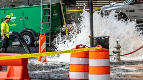 Crews working on a broken main on West Peachtree Street at 11th Street in Midtown had to use special equipment to stop the water. The needed device was brought by truck from Alabama with a police escort. (John Spink/AJC)