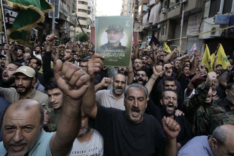 Hezbollah supporters carry pictures of Hezbollah commander Ibrahim Akil, during his funeral procession in Beirut's southern suburb, Sunday, Sept. 22, 2024. (AP Photo/Bilal Hussein)