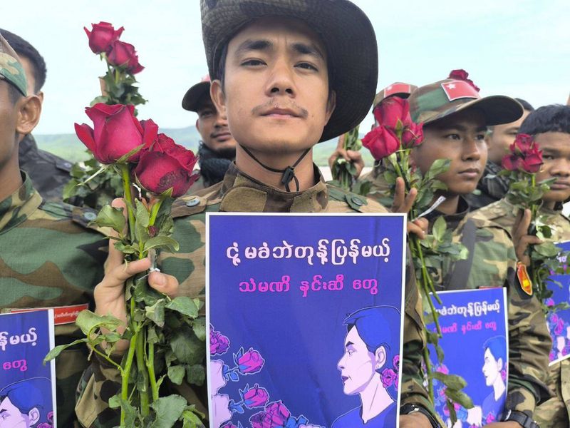In this photo provided by Thabeikkyin Township People’s Defense Force, the group's members pose for photographs with the roses and posters that read ''The steel roses will retaliate against the junta’s oppression without yielding,'' as they celebrate the 79th birthday of the country’s ousted leader Aung San Suu Kyi in Thabeikkyin township in Mandalay region, Myanmar on Wednesday, June.19, 2024. ( Thabeikkyin Township People’s Defense Force via AP)
