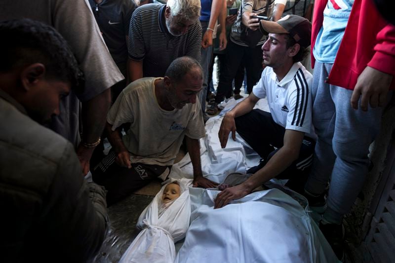 Palestinians mourn for relatives killed in the Israeli bombardment of the Gaza Strip at a hospital morgue in Deir al-Balah, Wednesday, Oct. 2, 2024. (AP Photo/Abdel Kareem Hana)