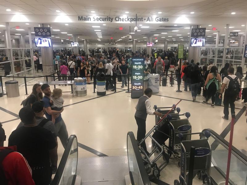 Memorial Day weekend travel is in full swing at Hartsfield-Jackson International Airport. Security lines for the main checkpoint stretched through the domestic terminal atrium and began extending into baggage claim by 7:30 a.m. Friday, May 24, 2019. (Photo: Kelly Yamanouchi/AJC)