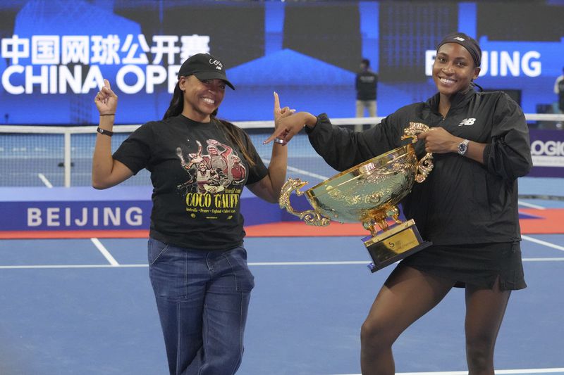 Coco Gauff of the United States, right, celebrates with her mother Candi Gauff after defeating Karolina Muchova of Czech Republic in the women's singles final match at the China Open tennis tournament at the National Tennis Center in Beijing, Sunday, Oct. 6, 2024. (AP Photo/Achmad Ibrahim)