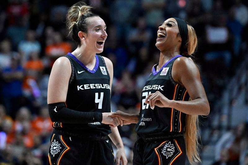 Connecticut Sun guards Marina Mabrey (4) and DiJonai Carrington (21) celebrate together during the second half of a first-round WNBA basketball playoff game against the Indiana Fever, Wednesday, Sept. 25, 2024, in Uncasville, Conn. (AP Photo/Jessica Hill)