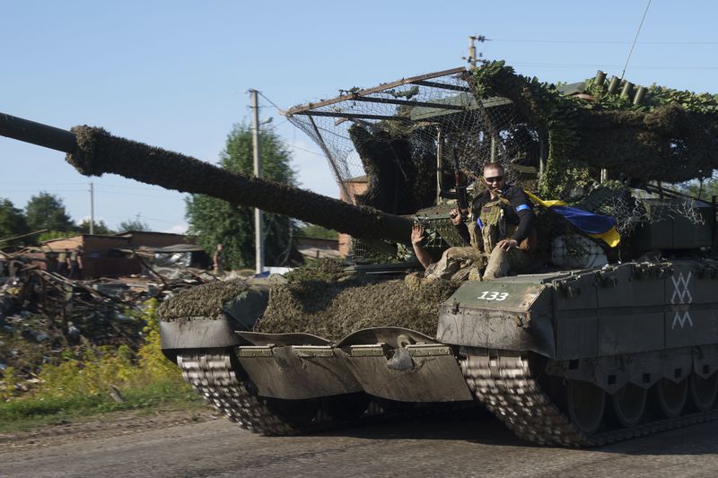 Ukrainian serviceman ride atop a trophy tank after returning from Russia near the Russian-Ukrainian border in Sumy region, Ukraine, Thursday, Aug. 15, 2024. (AP Photo/Evgeniy Maloletka)