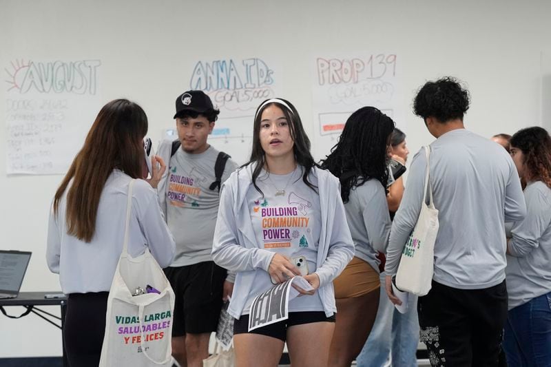 Poder In Action canvassers prepare to go door-to-door during a voter canvassing event Tuesday, Sept. 3, 2024, in Phoenix. (AP Photo/Ross D. Franklin)