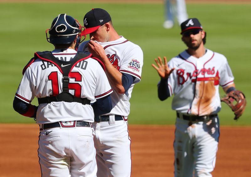 Braves catcher Travis d’Arnaud (16) confers with starting pitcher Drew Smyly as shortstop Dansby Swanson (background) approaches the mound after Smyly gave up a two-run homer to Arizona Diamondbacks David Peralta in the first inning of the second game of a doubleheader Sunday, April 25, 2021, at Truist PArk in Atlanta. Smyly relinquished five runs during the first inning. (Curtis Compton / Curtis.Compton@ajc.com)