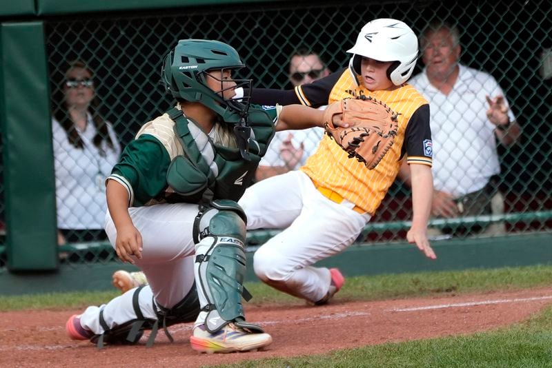 Lake Mary, Fla.'s Chase Anderson , right,slides past Taiwan catcher Yu Chia-Jui, left, as he scores on DeMarcos Mieses' double during the sixth inning of the the Little League World Series Championship game in South Williamsport, Pa., Sunday, Aug. 25, 2024. (AP Photo/Tom E. Puskar)