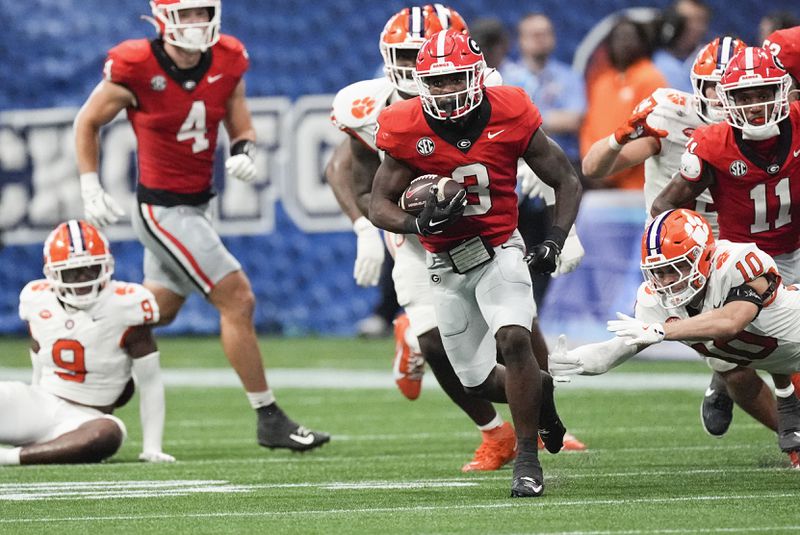 Georgia running back Nate Frazier (3) gets past Clemson cornerback Jeadyn Lukus (10) as he runs the ball during the second half of an NCAA college football game Aug. 31, 2024, in Atlanta. (AP Photo/John Bazemore)